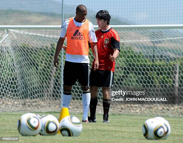 Germany's head coach Joachim Loew speaks with Germany's defender Jerome Boateng during a training session at the Verdura Golf and Spa resort, near...