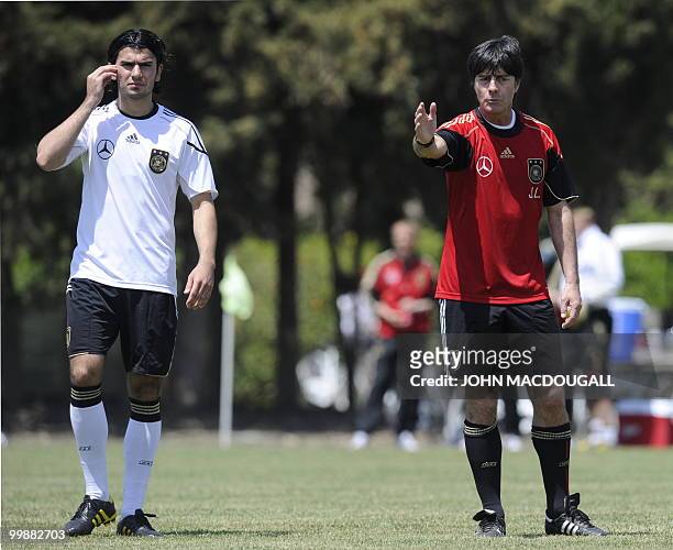 Germany's head coach Joachim Loew gestures as Germany's defender Serdar Tasci looks on during a training session at the Verdura Golf and Spa resort,...