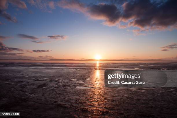 sonnenuntergang über einem gefrorenen see - casarsa stock-fotos und bilder