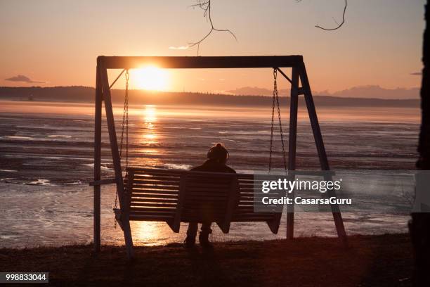 young unrecognizable woman enjoying mid summer sun - midnight sun stock pictures, royalty-free photos & images