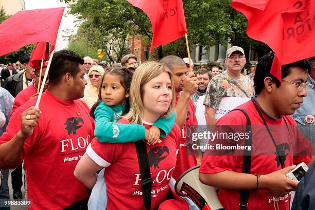 Brianna Connors, center, carries Esmi Sanchez during a protest by members of the Farm Labor Organizing Committee , outside the Massey Energy Co....