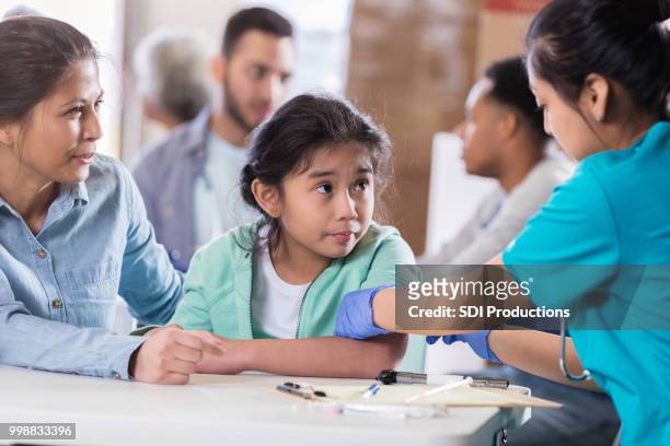 worried little girl receiving flu vaccine - receiving treatment concerned stock pictures, royalty-free photos & images