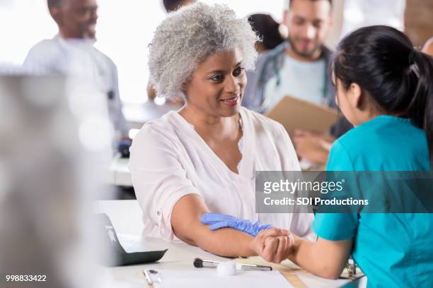 senior woman receiving flu vaccine - film and television screening stock pictures, royalty-free photos & images