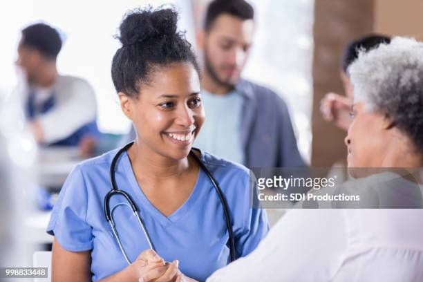cheerful nurse talking with senior female patient - film and television screening stock pictures, royalty-free photos & images