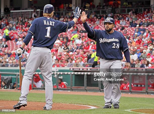 Prince Fielder of the Milwaukee Brewers is congratulated by Corey Hart after Fielder scored in the first inning during the game against the...