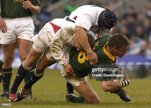 Bob Skinstad of South Africa is stopped by Jonny Wilkinson and Danny Grewcock of England during the Investec Challenge match between England and...