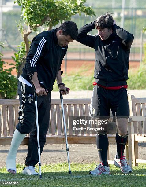Injured Michael Ballack speaks with head coach Joachim Loew during the German National Team training session at Verdura Golf & Spa Resort on May 18,...