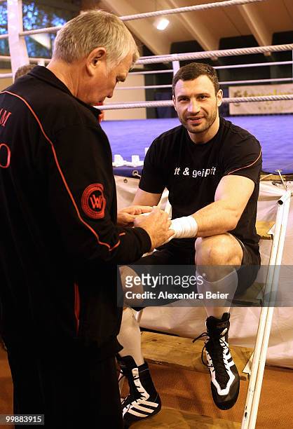 Ukrainian boxer Vitali Klitschko gets his hands wrapped by his coach Fritz Sdunek during a training session on May 18, 2010 in Going, Austria. The...