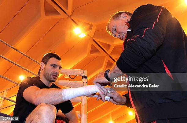 Ukrainian boxer Vitali Klitschko gets his hands wrapped by his coach Fritz Sdunek during a training session on May 18, 2010 in Going, Austria. The...