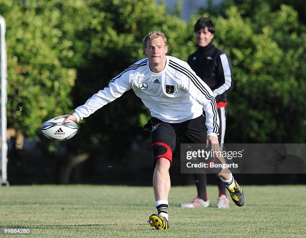 Goalkeeper Manuel Neuer exercises with a rugby ball whilst head coach Joachim Loew watches him during a German National Team rugby training session...