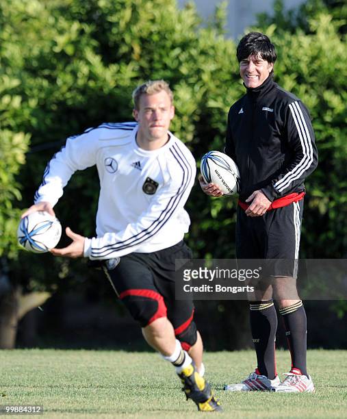 Goalkeeper Manuel Neuer of Germany exercises with a rugby ball whilst German head coach Joachim Loew watches him during a German National Team rugby...