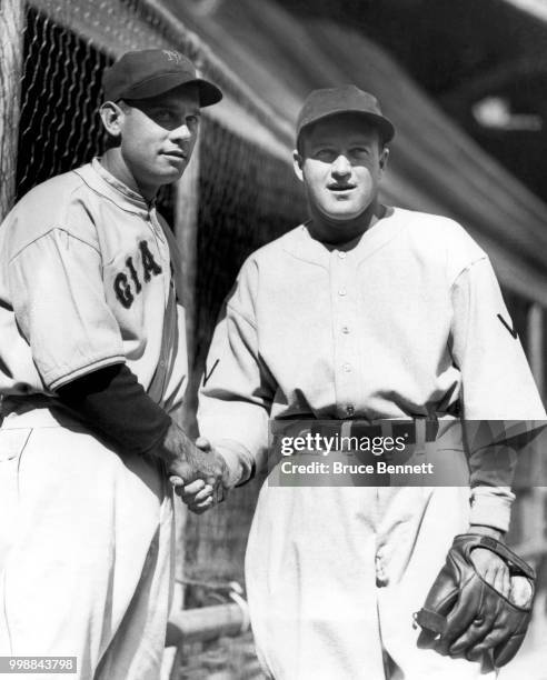 Manager/player Bill Terry of the New York Giants and manager/player Joe Cronin of the Washington Senators shake hands as they pose for a portrait...