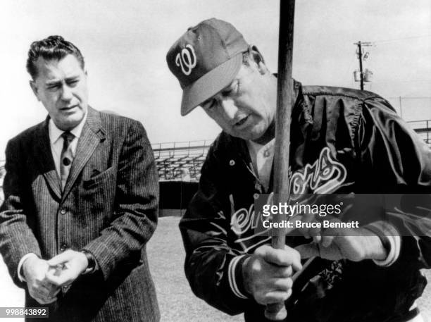 Manager Ted Williams of the Washington Senators shows the grip on the fungo bat that he used to hold his hands as former Detroit Tiger Don Kolloway...