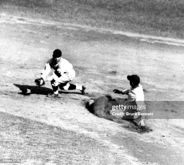 Roger Peckinpaugh of the Washington Senators slides safely into second base after Max Carey of the Pittsburgh Pirates made the error as second...