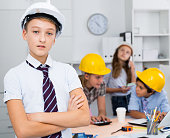 Teenager boy engineer and children with plan