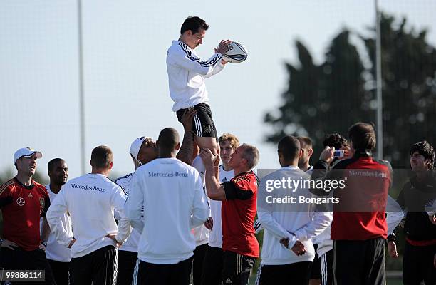 Piotr Trochowski of Germany is lifted in the air by his fitness coach Marc Verstegen and rugby player Jonah Tali Lomu of New Zealand during a German...