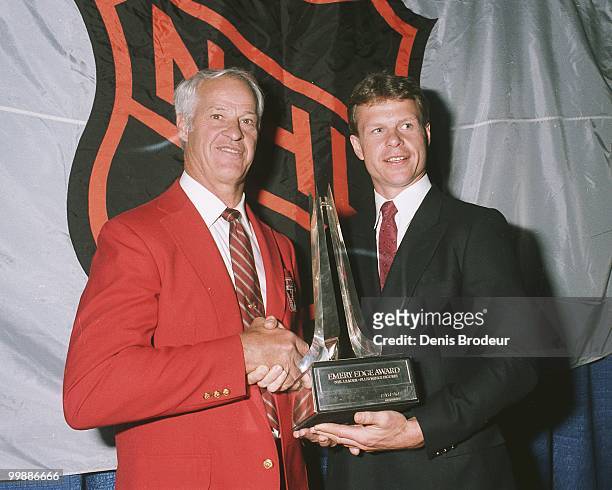 Gordie Howe presents his son Mark Howe with the Emery Edge Award for being the NHL Leader in plus/minus figures at the Montreal Forum in Montreal,...