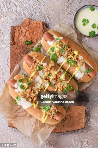 hot dogs with cheese sauce and mustard - mustard stock-fotos und bilder