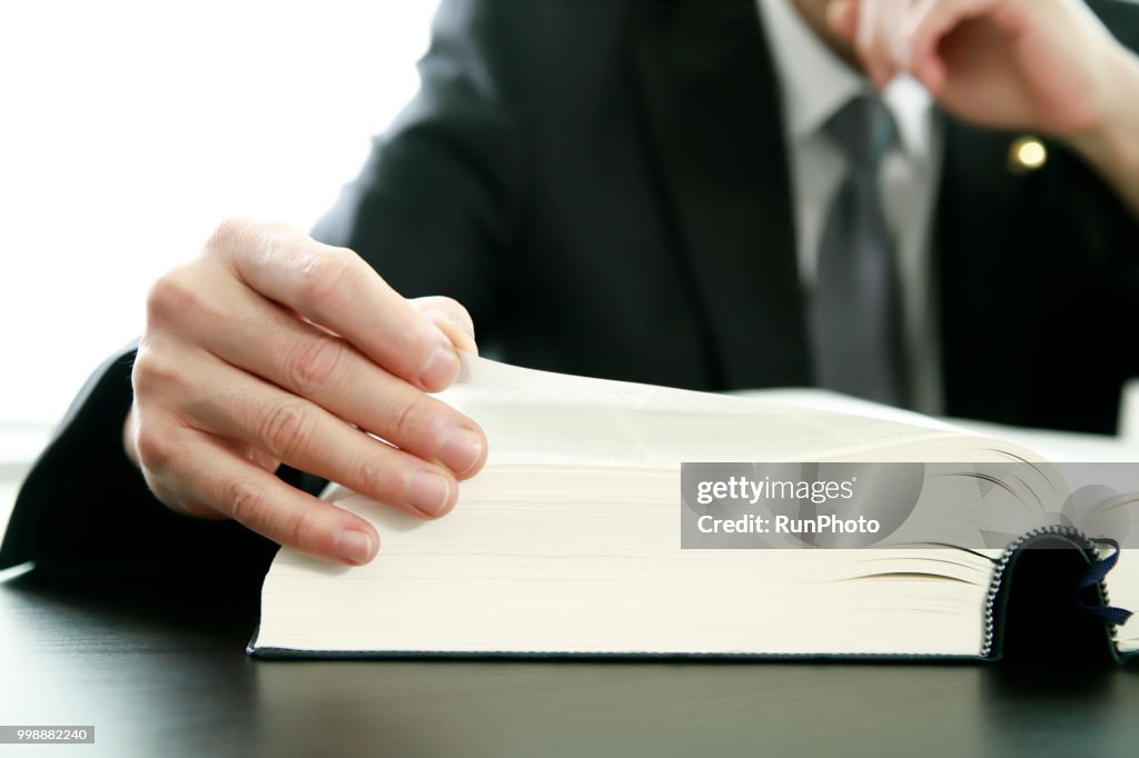 Close up of lawyer reading law book at desk