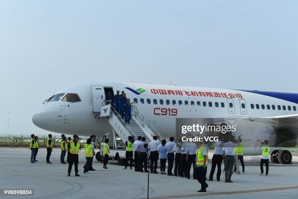 Flight crew members deplane after the No.102 C919 passenger jet lands at Dongying Shengli Airport on July 12, 2018 in Dongying, Shandong Province of...