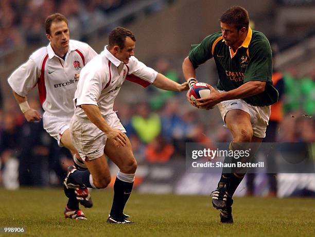 Bob Skinstad of South Africa breaks away from Austin Healey of England during the Investec Challenge match between England and South Africa at...