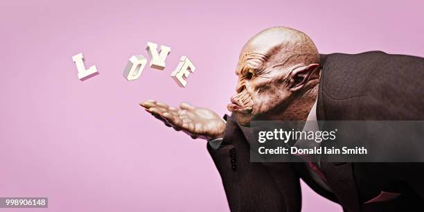 ogre businessman wearing suit and tie blowing kiss with love letters - ogre fictional character fotografías e imágenes de stock