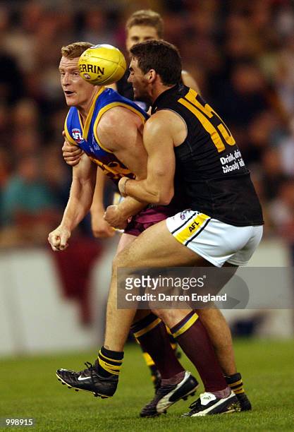 Michael Voss of Brisbane gets his handball away despite the efforts of Leon Cameron of Richmond during the AFL second Preliminary Final between the...