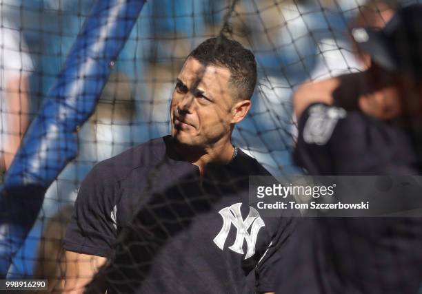Giancarlo Stanton of the New York Yankees watches from outside the batting cage during batting practice before the start of MLB game action against...