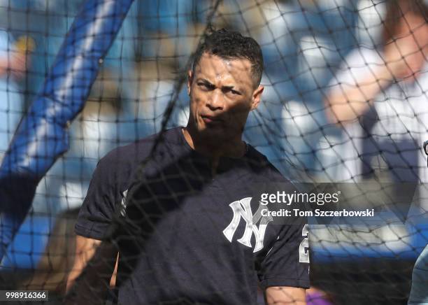 Giancarlo Stanton of the New York Yankees watches from outside the batting cage during batting practice before the start of MLB game action against...