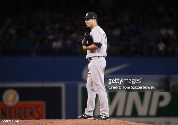 David Hale of the New York Yankees looks in before delivering a pitch in the eighth inning during MLB game action against the Toronto Blue Jays at...