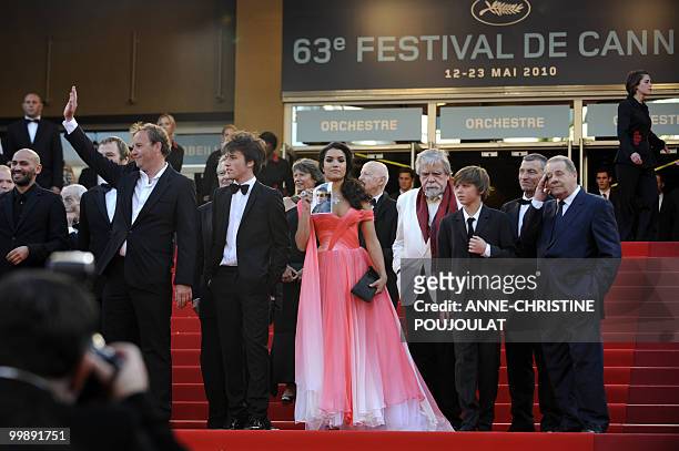 French actress Sabrina Ouazani holds a portrait of an actor in the film who recently died as she arrives with French director Xavier Beauvois and...