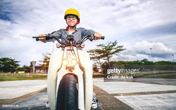 boy riding a bike - moped stock pictures, royalty-free photos & images