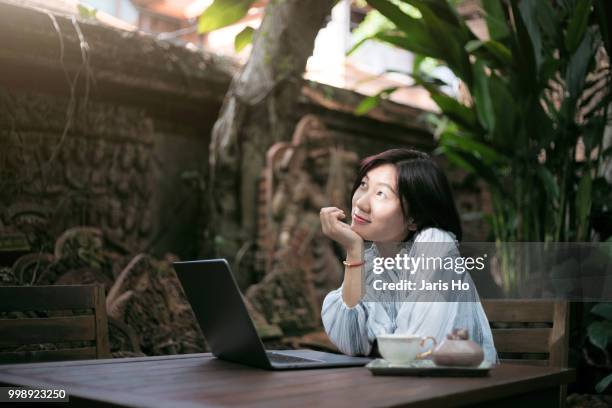 young woman searching information on laptop in the courtyard. - ho stock pictures, royalty-free photos & images