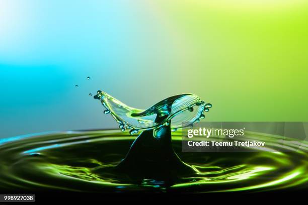 water drop collision close up image with a green and blue background - teemu tretjakov stock pictures, royalty-free photos & images