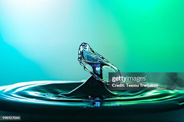 water drop collision close up image with a green and blue background - teemu tretjakov fotografías e imágenes de stock