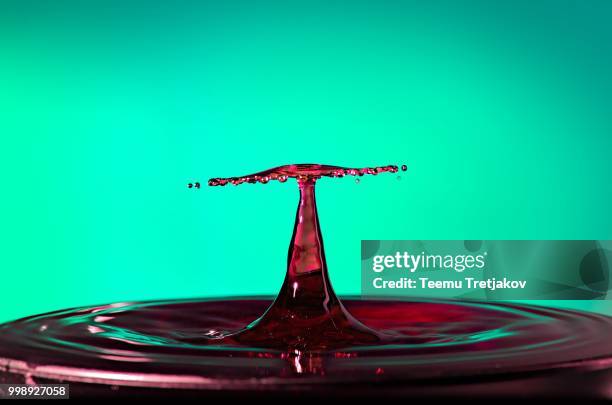 water drop collision close up image with a green background - teemu tretjakov stock pictures, royalty-free photos & images