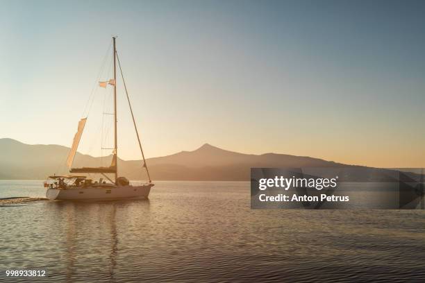 lonely yacht sailing on silent sea. aegina island, greece - anton petrus fotografías e imágenes de stock