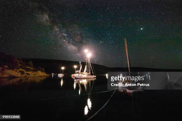 the milky way over the yachts. dokos island, greece - anton petrus stock pictures, royalty-free photos & images