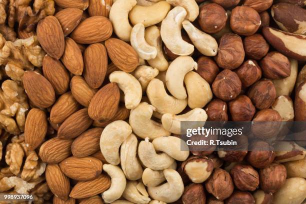 mixe of various nuts background above closeup - fruit-à-coque photos et images de collection