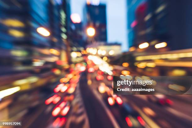 car trails rushing in central hong kong - zoom out stock pictures, royalty-free photos & images