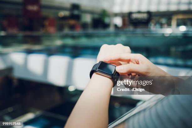 close up of woman checking the shopping list on smart watch in a shopping mall - wearable ストックフォトと画像