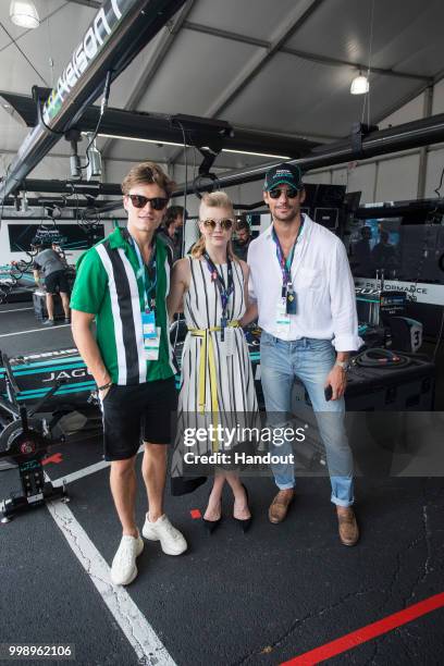 In this handout provided by FIA Formula E, Oliver Cheshire, Natalie Dormer and David Gandy visit the Jaguar Racing garage during the New York City...