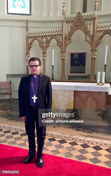 Dietrich Brauer , archbishop of the Evangelical Lutheran Church in Russia is standing in front of a banner of the 500th anniversary of the...