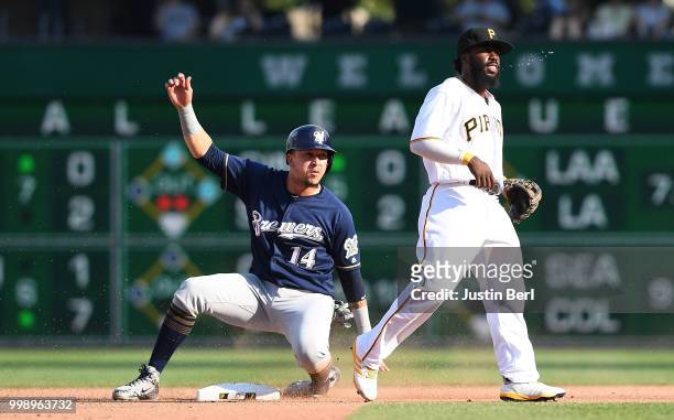 Hernan Perez of the Milwaukee Brewers slides safely past Josh Harrison of the Pittsburgh Pirates for a stolen base in the seventh inning during the...
