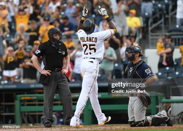 Gregory Polanco of the Pittsburgh Pirates points to the sky in front of Jacob Nottingham of the Milwaukee Brewers after hitting a solo home run in...
