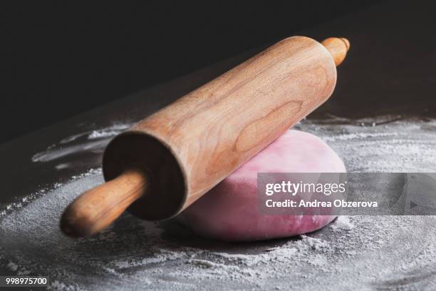 rolling pin and pink sugar paste on kitchen counter - rolling pin stock-fotos und bilder