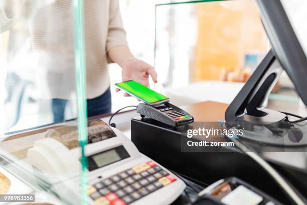 contactless payment at the register - zoranm imagens e fotografias de stock