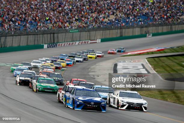 Martin Truex Jr., driver of the Auto-Owners Insurance Toyota, leads the field past the green flag to start the Monster Energy NASCAR Cup Series...