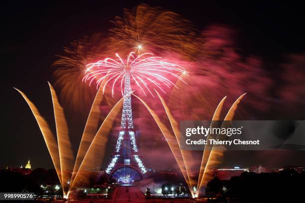 Fireworks burst around the Eiffel Tower as part of Bastille Day celebrations on July 14, 2018 in Paris, France. The theme of the fireworks of this...