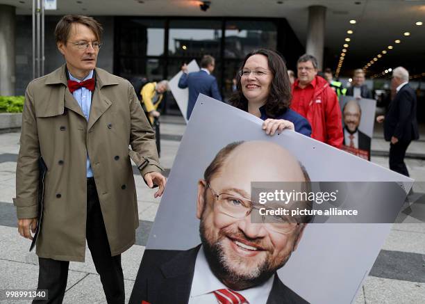 Federal Labour Minister Andrea Nahles, and the SPD's Karl Lauterbach, walking in the Roncalli Square holding an SPD campaign poster with the text...